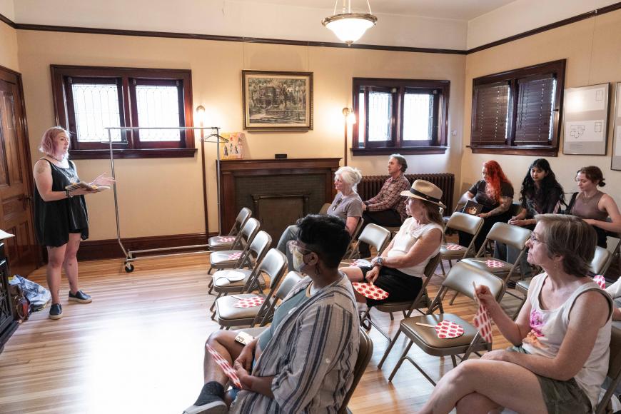 Interior of the Center for Colorado Women's History History lab, where an audience is sat in a row of chairs listening to  a presenter.