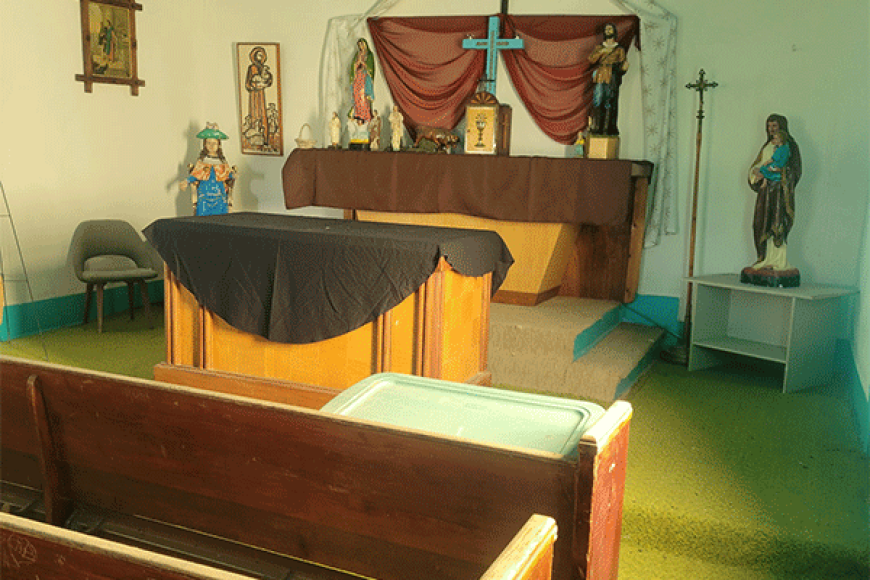Colorful interior of church in Avondale. Features pews, an altar, and some religious paintings and statues.
