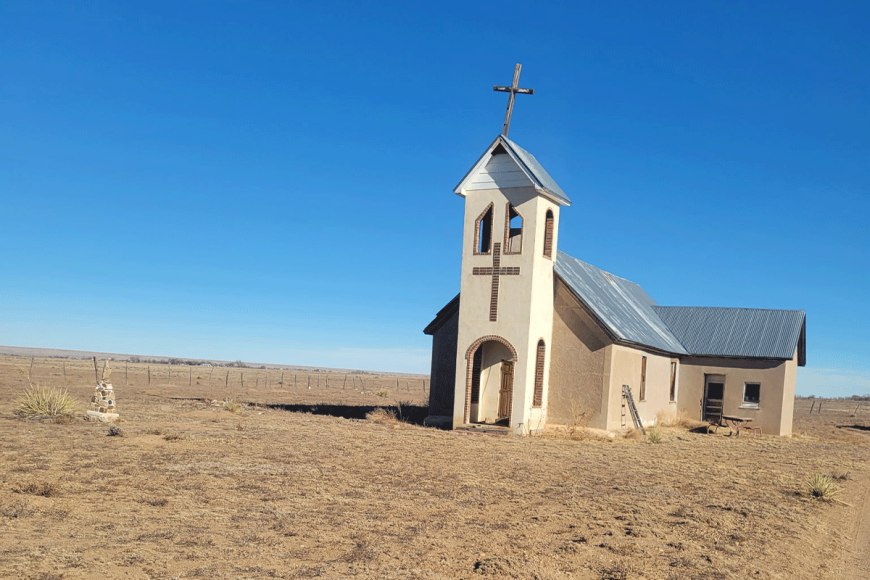 Exterior of simple historic church along an unpaved road in Avondale.