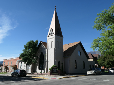 The photo is of the north and west sides of the church and prominently features the tower which contains the entrance to the church.