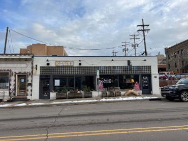 Pictured is the historic Piggly Wiggly in Golden. It is a mid-20th Century storefront building that features a ribbon set of four display windows flanked by twin wood and glass doors with transom windows above the eastern door. 